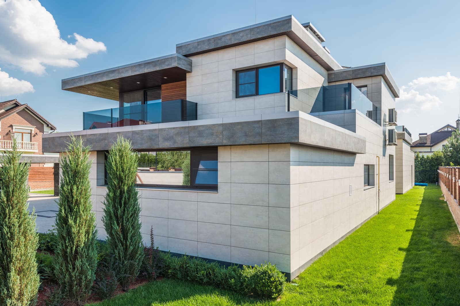 Contemporary two-story house with a green front lawn under a blue sky