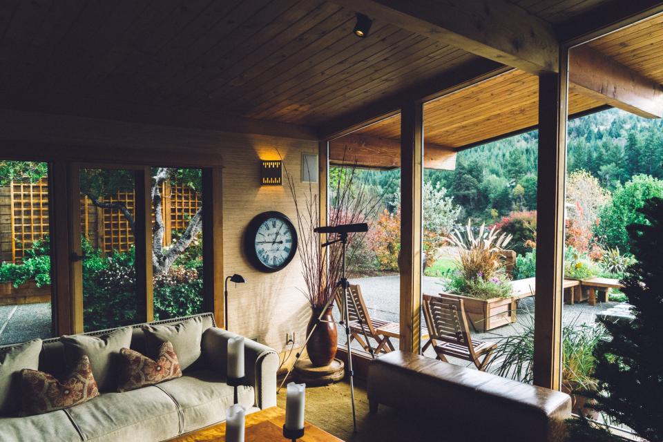 Covered wood porch with outdoor seating and a garden view